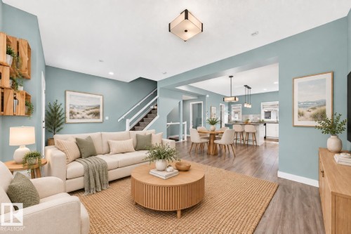 Open concept living area with wood-finish flooring, recessed lighting, and a modern ceiling fixture - #56 804 Welsh Dr Sw, Edmonton, AB 