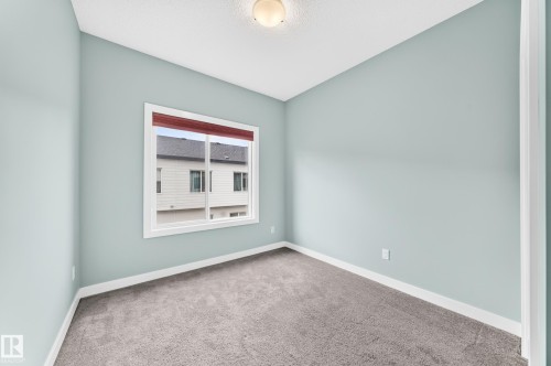 Light-colored carpeting with white trim, light blue painted walls, and a single window - #56 804 Welsh Dr Sw, Edmonton, AB 