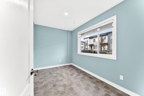 Hexagonal tile flooring, light blue wall paint, white trim, recessed ceiling lighting, and a white-framed window - #56 804 Welsh Dr Sw, Edmonton, AB 