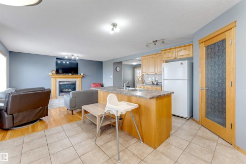 Open-concept kitchen and living area with tile and wood-finish flooring - 4510 164A Ave Nw, Edmonton, AB 