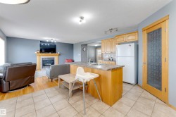 Open-concept kitchen and living area with tile and wood-finish flooring - 