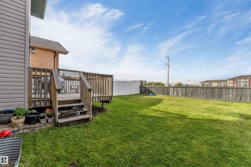 Expansive grassy backyard featuring a wood deck with stairs, a privacy fence, and a vinyl fence - 4510 164A Ave Nw, Edmonton, AB 