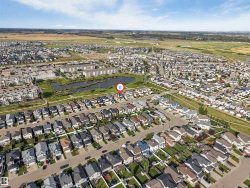 Residential neighborhood with varied single-family homes, adjacent to a pond and green spaces, and surrounded by open fields - 4510 164A Ave Nw, Edmonton, AB 