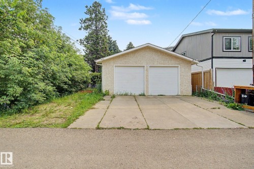 Detached two-car garage with white paneled doors and stucco exterior - 8710 83 Avenue Nw, Edmonton, AB - Outdoor