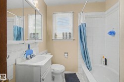 Bathroom featuring a white vanity with integrated sink, toilet, and bathtub with overhead shower - 
