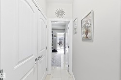White paneled doors with brushed nickel hardware, light tile flooring, and white wall finishes - 