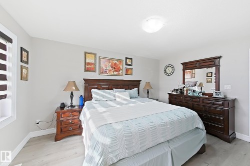 Light gray walls, wood-finish flooring, and a flush mount ceiling light fixture - 144 52 Street Sw, Edmonton, AB 