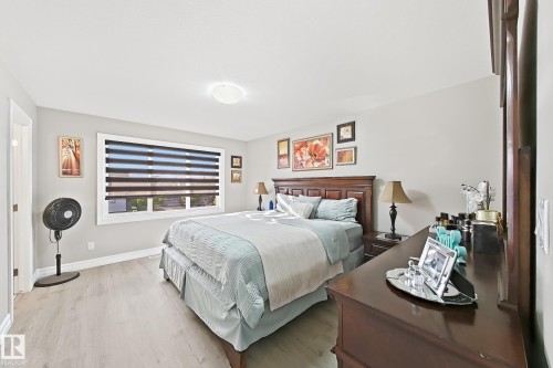 Light wood-finish flooring, a window with layered shades, and a recessed ceiling light fixture - 144 52 Street Sw, Edmonton, AB 