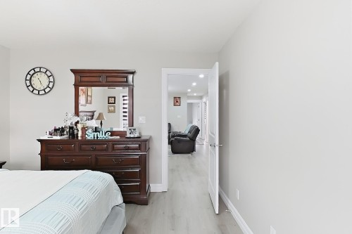 Wood-finish flooring throughout, light-toned wall paint, and white trim - 144 52 Street Sw, Edmonton, AB 