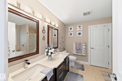 Double vanity with integrated sinks and chrome fixtures, framed mirrors, and overhead wall sconce lighting - 