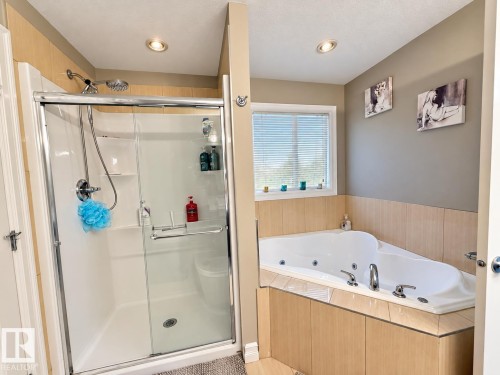 Spacious bathroom featuring a glass-enclosed shower, built-in corner bathtub, and recessed lighting - 144 52 Street Sw, Edmonton, AB 