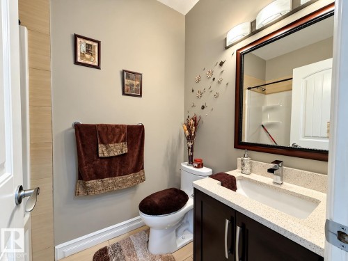 Dark wood-finish vanity with a light-toned countertop and integrated sink - 144 52 Street Sw, Edmonton, AB 