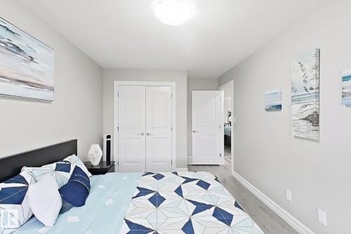 Light gray walls, wood-finish flooring, white door casings, and a flush mount ceiling light fixture - 144 52 Street Sw, Edmonton, AB 