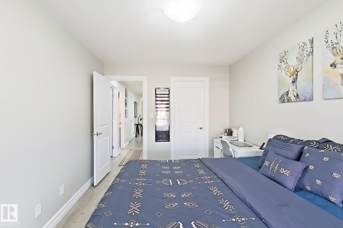 Neutral wall color, light wood-finish flooring, white trim, and a flush mount ceiling light - 144 52 Street Sw, Edmonton, AB 
