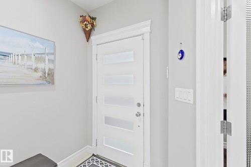 White interior door with frosted panels, contemporary door hardware, and crisp white trim - 144 52 Street Sw, Edmonton, AB 