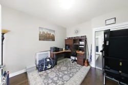 Hardwood-finish flooring, light neutral wall paint, and a built-in corner desk unit with shelving - 