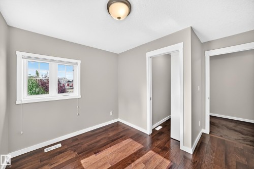 Wood-finish flooring, neutral wall tones, white trim, and a ceiling-mounted light fixture - 3329 West Court Nw, Edmonton, AB 
