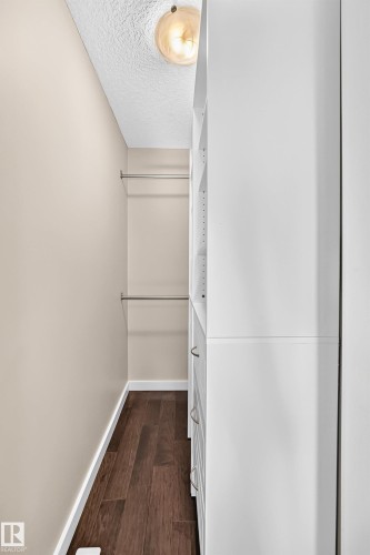 Built-in closet system with multiple drawers and shelving, wood-finish flooring, two clothing rods, and recessed lighting - 3329 West Court Nw, Edmonton, AB 
