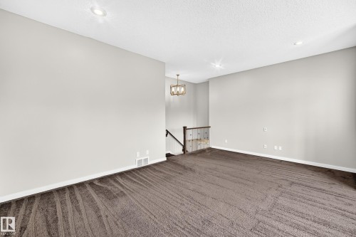 Neutral wall paint, textured ceiling, recessed lighting, carpet flooring, and a chandelier light fixture - 3329 West Court Nw, Edmonton, AB 