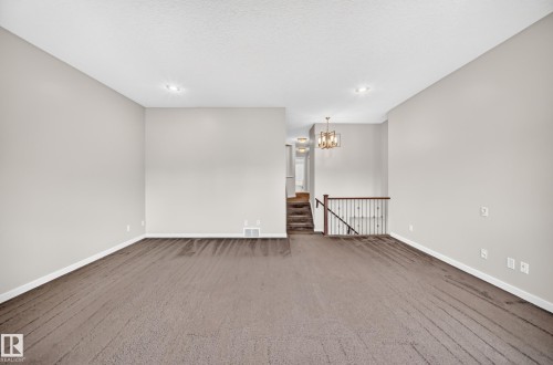 Expansive carpeted room with neutral wall tones and recessed lighting - 3329 West Court Nw, Edmonton, AB 