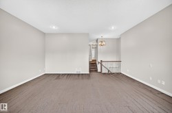 Expansive carpeted room with neutral wall tones and recessed lighting - 