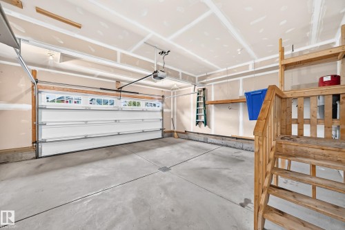 Concrete flooring, automatic garage door opener, wood shelving, wood stairs, wood railing - 3329 West Court Nw, Edmonton, AB 