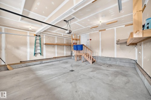 Concrete flooring, garage door opener, built-in wooden shelving, and interior access door - 3329 West Court Nw, Edmonton, AB 