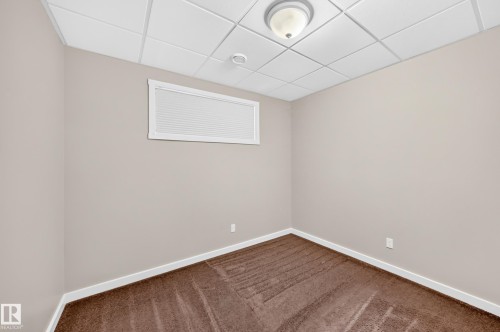 Neutral-toned walls, brown patterned carpeting, and white trim - 3329 West Court Nw, Edmonton, AB 