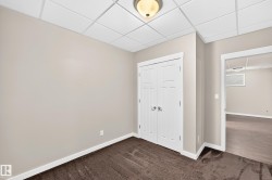 Neutral wall paint, plush carpet flooring, white trim, paneled double doors, and a drop ceiling with recessed lighting - 