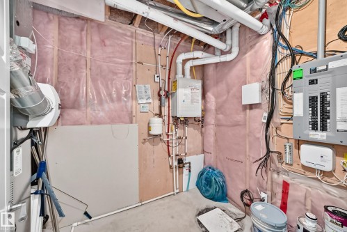 Utility room featuring an electrical panel, water heater, and exposed insulation - 3329 West Court Nw, Edmonton, AB 