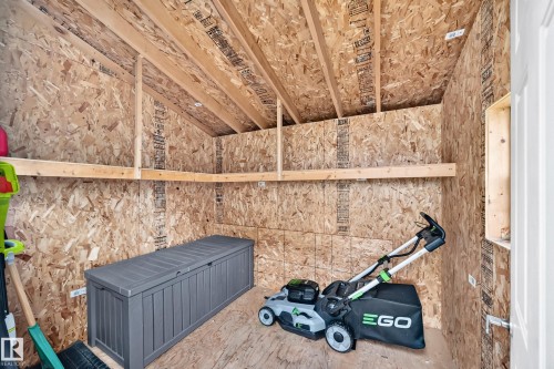 Storage shed with exposed wood framing, oriented strand board walls, and built-in shelving - 3329 West Court Nw, Edmonton, AB 