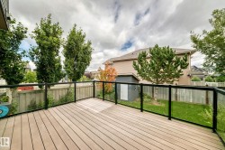 Spacious outdoor deck with composite decking and glass panel railings - 