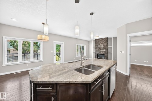 Kitchen island with a double basin sink and a high-arc faucet - 3329 West Court Nw, Edmonton, AB 