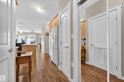 Wood-finish flooring, white paneled doors, and a built-in refrigerator - #420 9820 165 St Nw, Edmonton, AB 