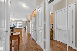 Wood-finish flooring, white paneled doors, and a built-in refrigerator - 