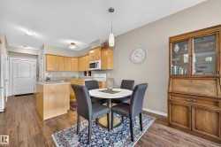 Kitchen featuring light wood cabinetry, white appliances, and a peninsula - 
