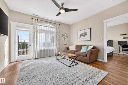 Wood-finish flooring, a ceiling fan with integrated lighting, and a glass-paneled door - #420 9820 165 St Nw, Edmonton, AB 