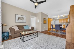 Open-concept living space featuring wood-finish flooring, a ceiling fan with integrated lighting, and recessed lighting - 