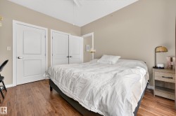 Wood-finish flooring, neutral wall tones, white trim, and white paneled doors - 