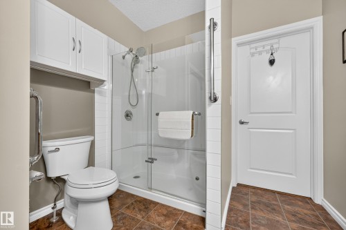 Shower with glass enclosure, white subway tile surround, and grab bar - #420 9820 165 St Nw, Edmonton, AB 