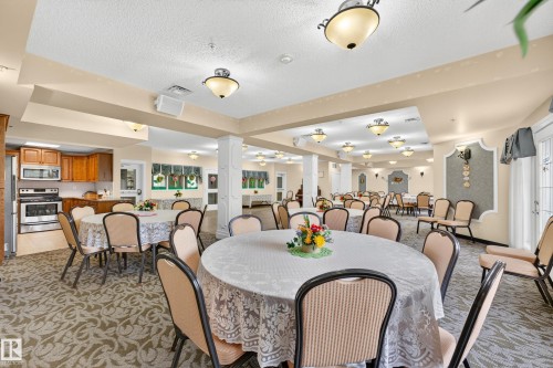 Expansive room featuring multiple round tables, patterned carpeting, and recessed ceiling lighting - #420 9820 165 St Nw, Edmonton, AB 
