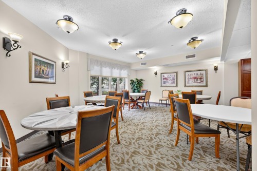Recessed lighting, wall sconces, patterned carpet, window treatments, and built-in cabinetry - #420 9820 165 St Nw, Edmonton, AB 