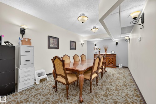 Recessed ceiling lighting, decorative wall sconces, patterned carpeting, and a built-in ceiling feature - #420 9820 165 St Nw, Edmonton, AB 