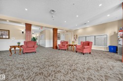 Patterned carpeting, recessed lighting, decorative wall sconces, wood-paneled columns, and white wainscoting - 