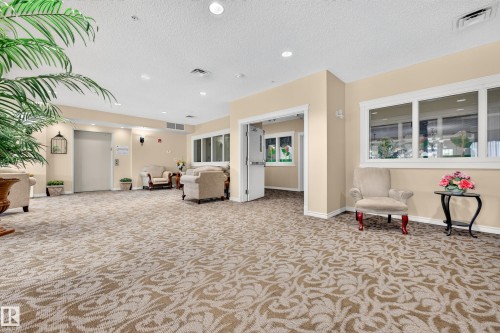 Recessed lighting, patterned carpeting, white trim, multiple windows, and a built-in elevator - #420 9820 165 St Nw, Edmonton, AB 