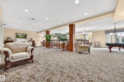 Recessed lighting, patterned carpet flooring, decorative wood columns, wrought iron railing, and a built-in fireplace - 