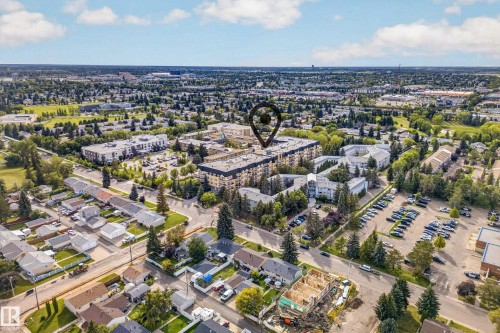 Aerial perspective showcasing a residential neighborhood with a mix of single-family homes and multi-story apartment buildings - #420 9820 165 St Nw, Edmonton, AB 