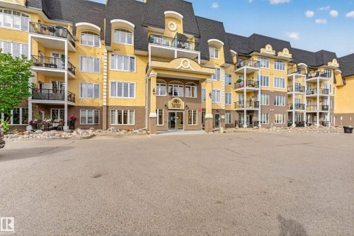 Multi-level building with individual balconies and a prominent central entrance - #420 9820 165 St Nw, Edmonton, AB 