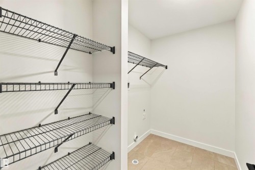Built-in wire shelving and neutral wall finishes in a dedicated utility space featuring tile flooring - 5852 Raven Crescent Nw, Edmonton, AB 