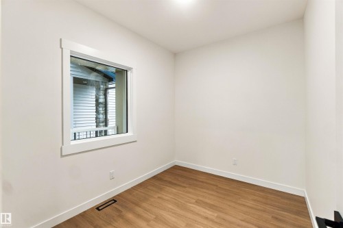 Wood-finish flooring, white walls, and a single window with white trim - 5852 Raven Crescent Nw, Edmonton, AB 